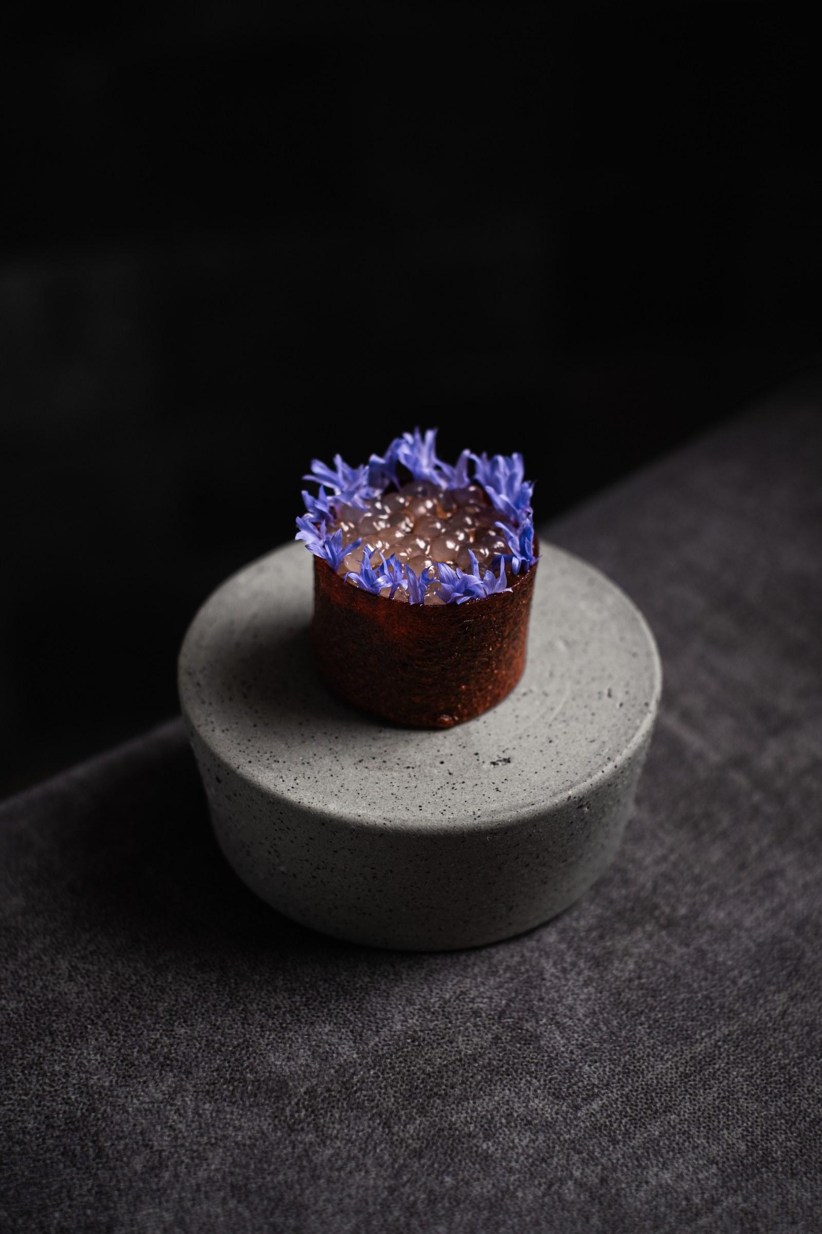 Berenjena con flores sobre base de piedra