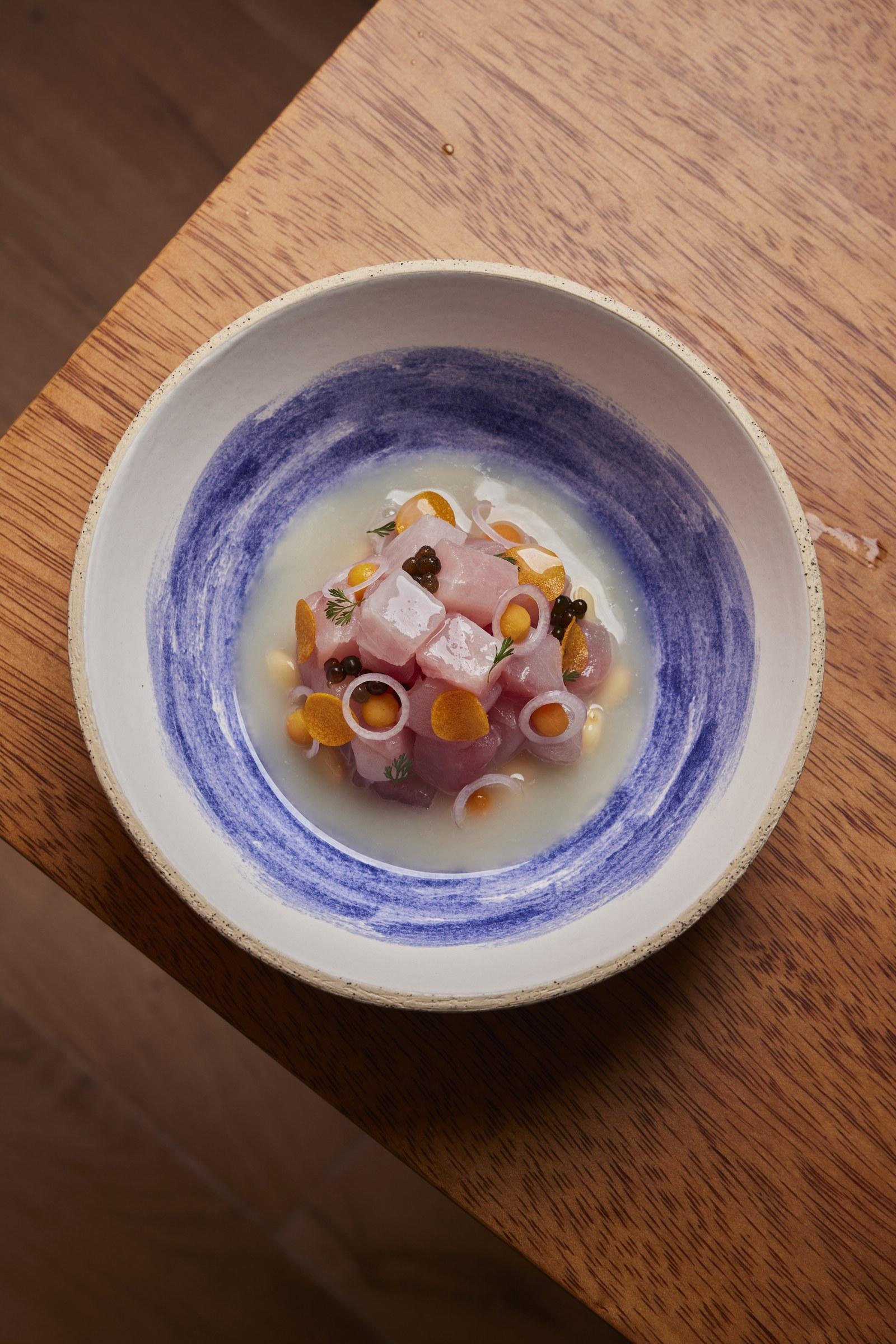 Cebiche servido en plato de cerámica azul pintado a mano